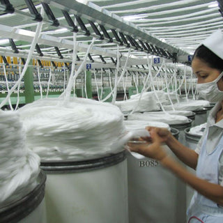 A worker inspecting the fabric from the production line